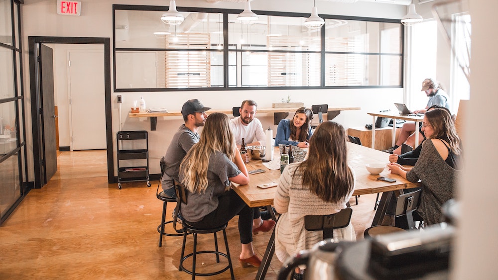 A team working together around a long table in a bright, open office